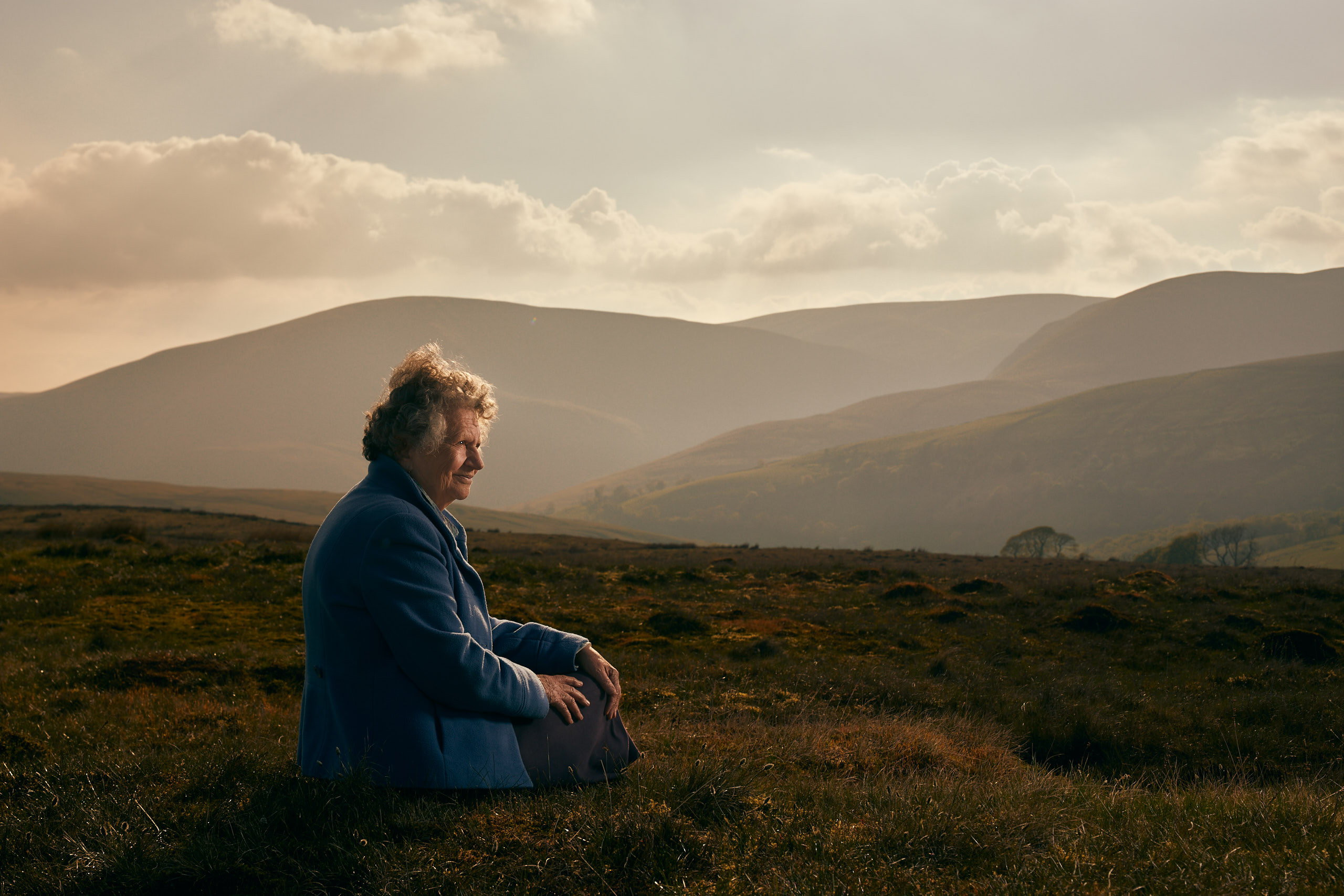 Portrait of Sue sat looking at the Cumbrian fells